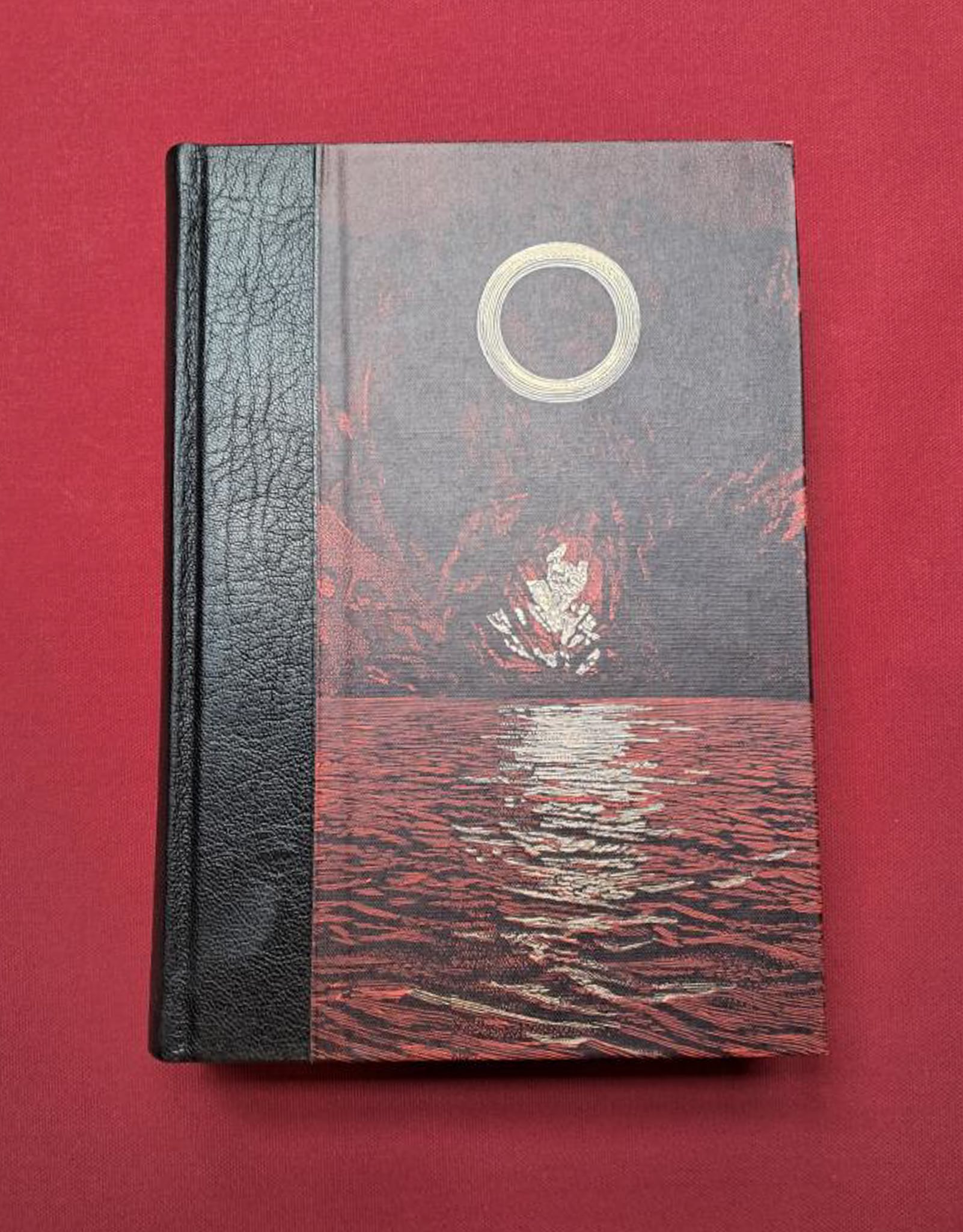 Legends of the ring. A dark red-brown sea and mountain with a silver ring in the middle of the cover