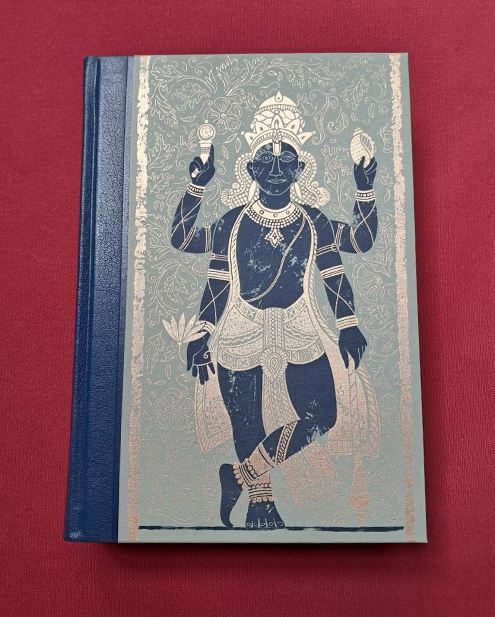 Myths and legends of india. A mythological character in dark blue, on a light background on the cover. Set on dark red background