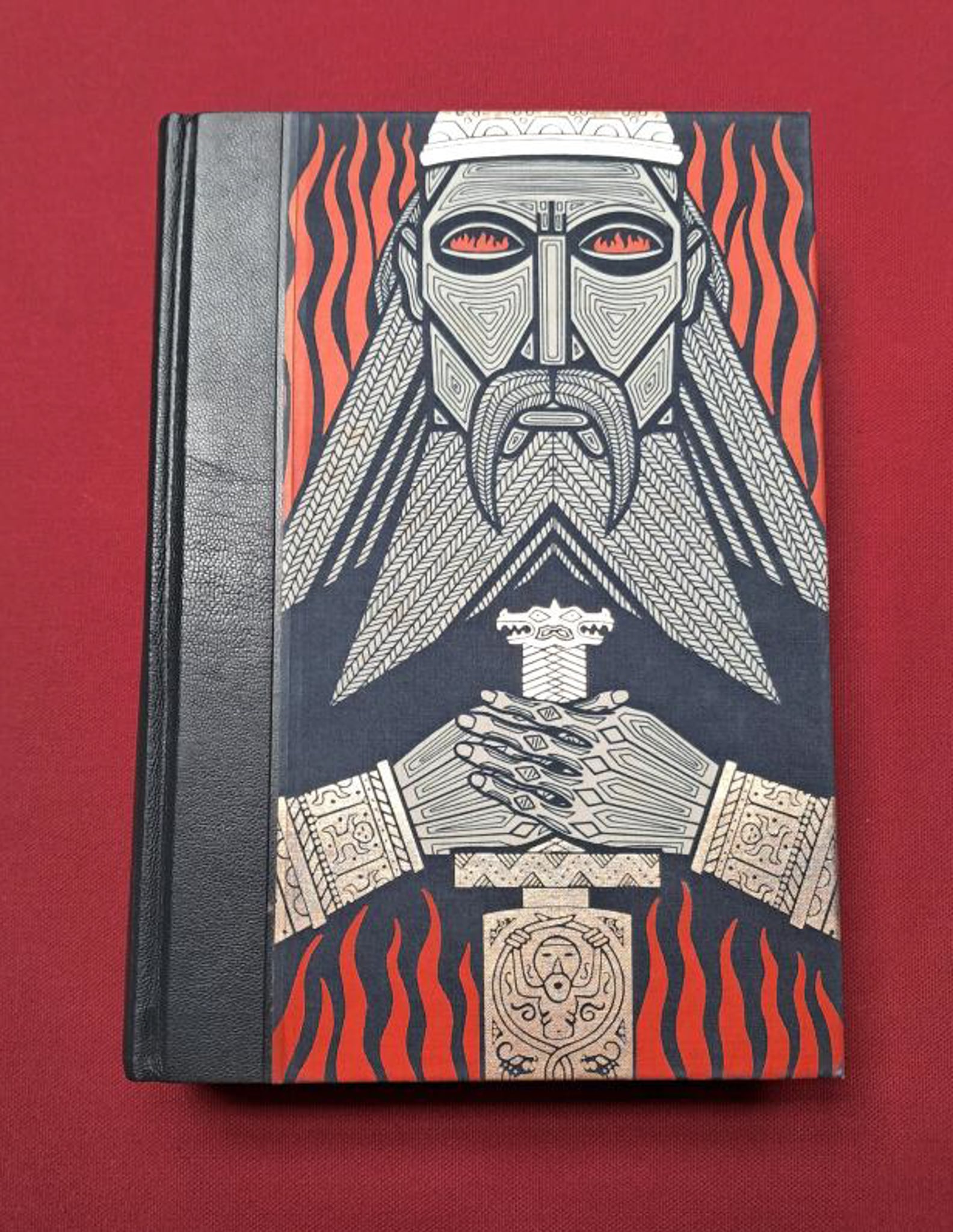 The Icelandic Sagas. A dark blue/grey stern character holding a sword to their chest on the cover, set on a dark red backrgound