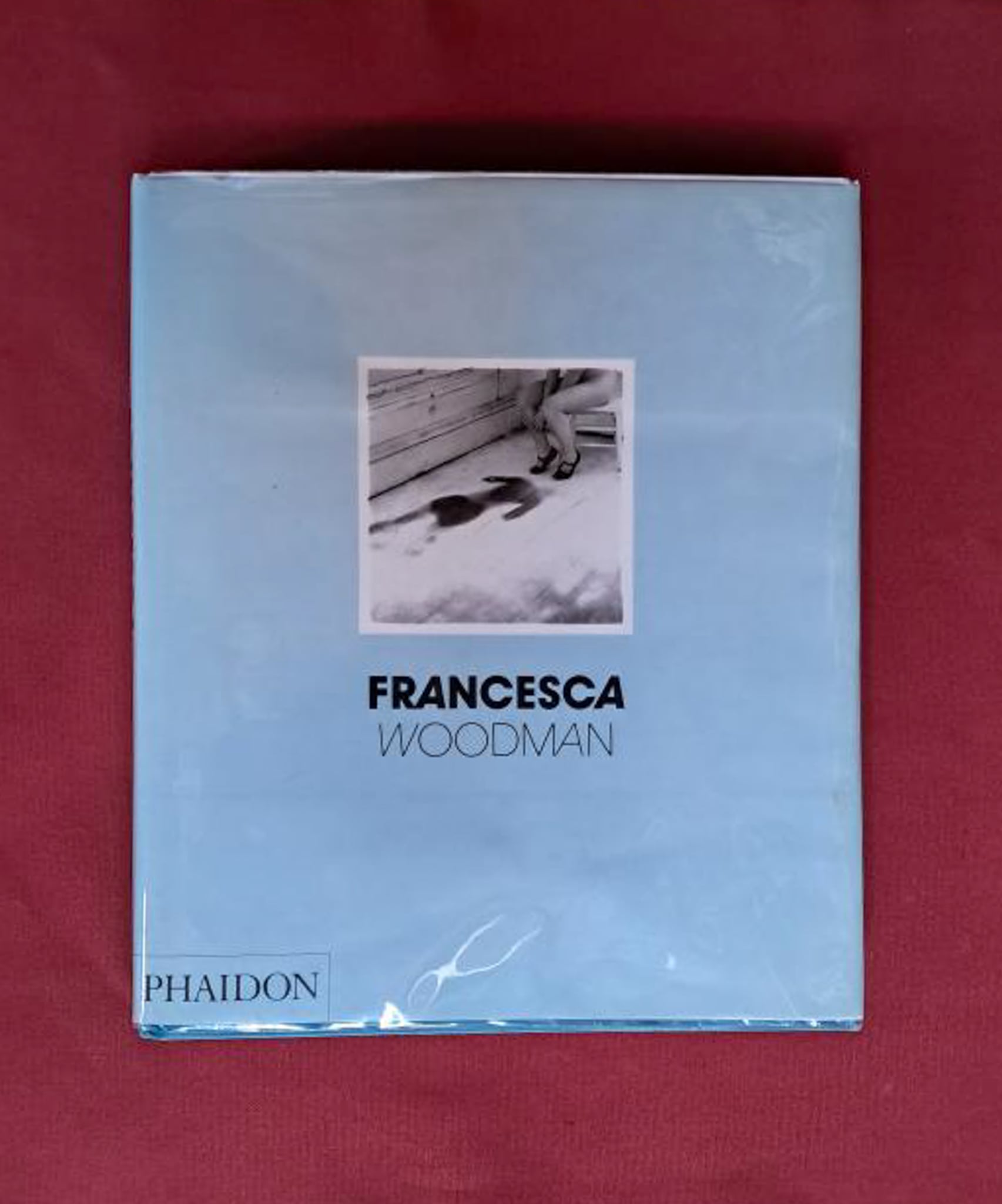 Francesca Woodman. Pale blue book cover set on a dark red backgrond